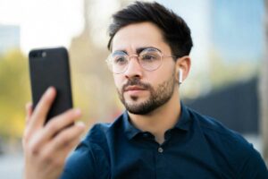 Junger Mann identifiziert sich mit Face-Security am Smartphone im Zusammenhanf mit Endpoint Security