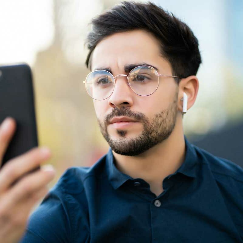 Junger Mann identifiziert sich mit Face-Security am Smartphone im Zusammenhanf mit Endpoint Security