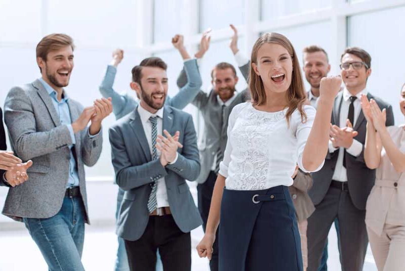 jubelnde Teamkolleg:innen beklatschen Chefin